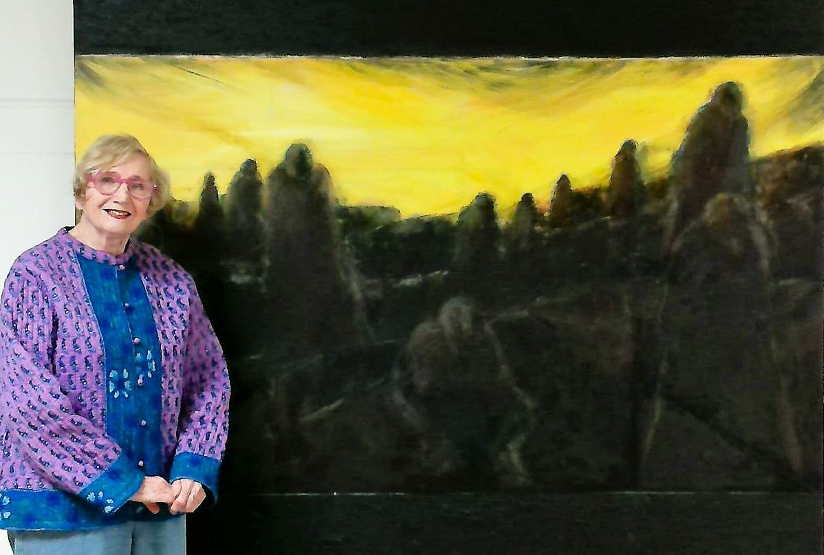 ,Judith Jaffe standing next to her painting titled "Monuments"