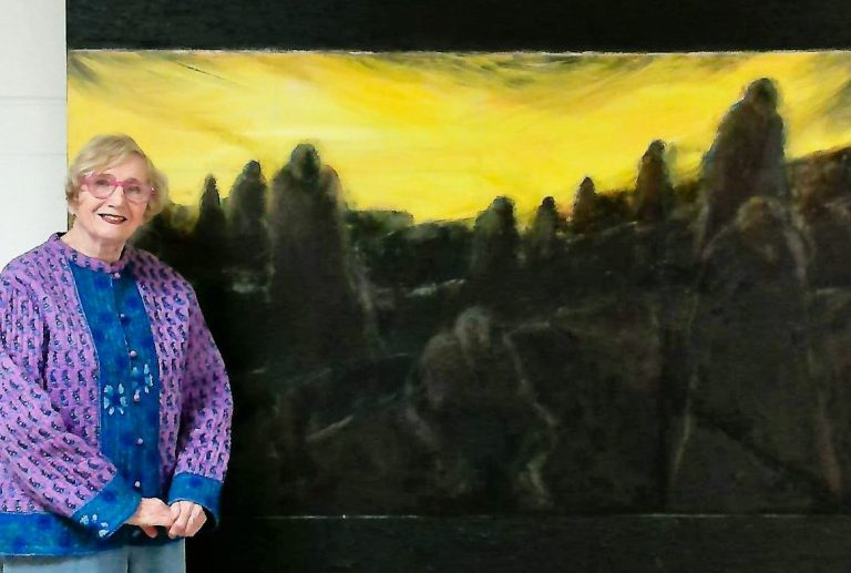 ,Judith Jaffe standing next to her painting titled "Monuments"